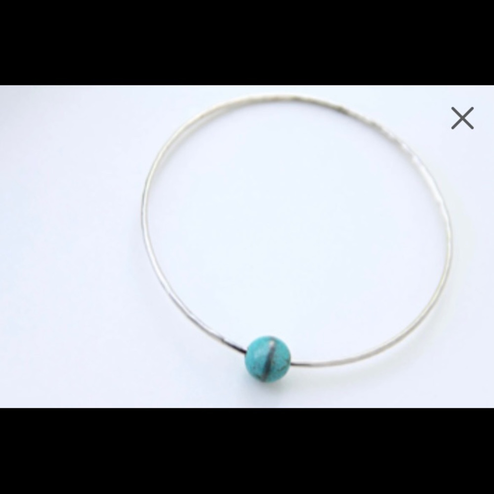 Handcrafted sterling silver bangle bracelet with a floating turquoise bead